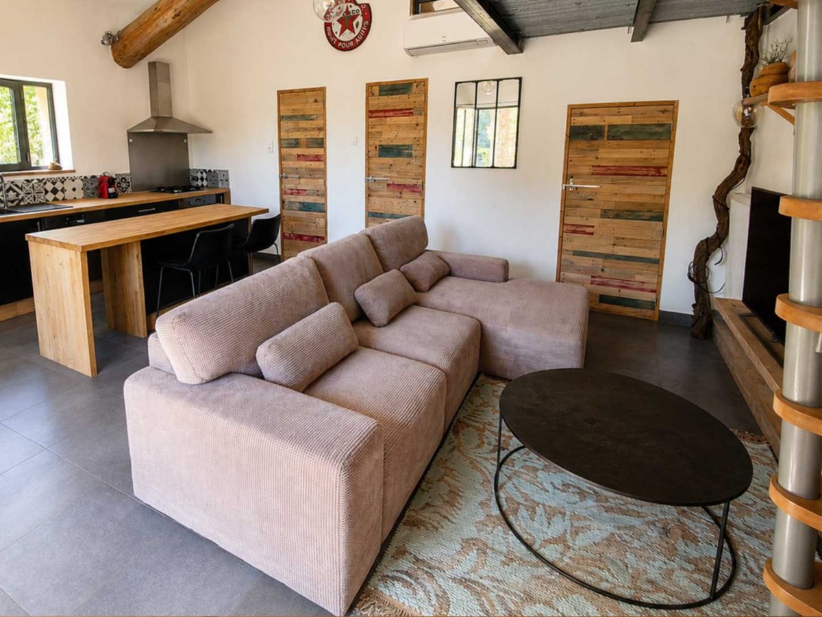 Salon avec coin repas et portes en bois récupéré
